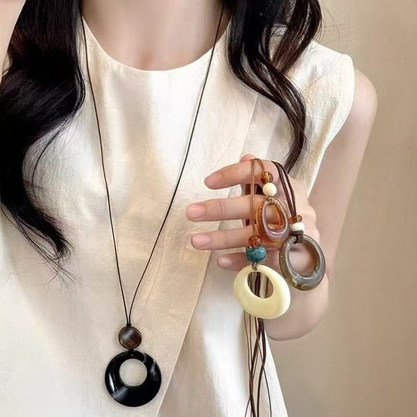 Long black rope necklace with ring pendant
