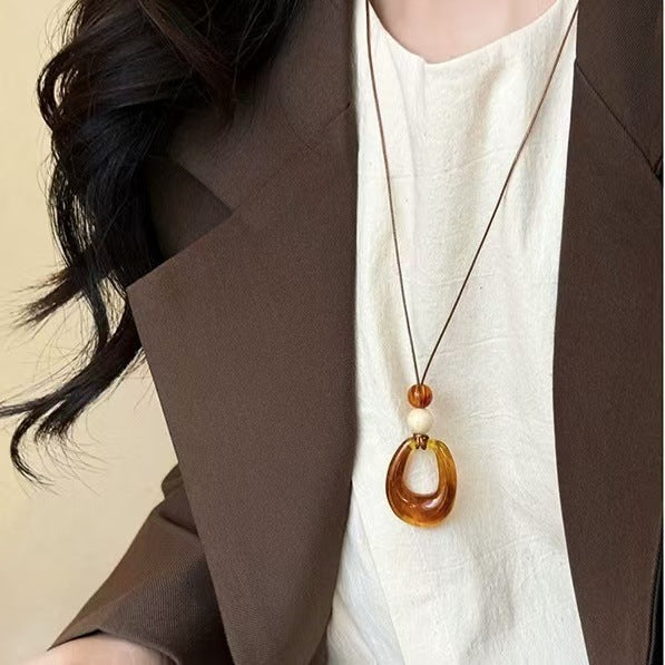 Long black rope necklace with ring pendant